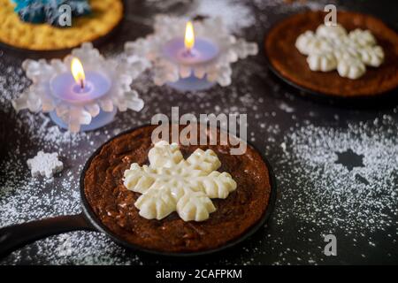 Hausgemachte Brownie und Schokolade Chip Cookie mit Schneeflocken Süßigkeiten auf Eisen Pfanne dekoriert. Weihnachtsfeiertage. Stockfoto