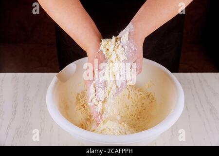 Der Koch mischt Butter, Zucker und Mehl mit den Händen. Stockfoto