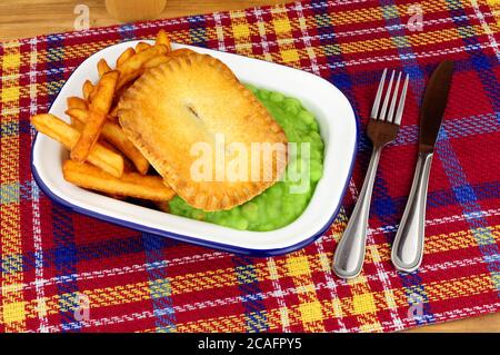 Steak und Kidney Pie und Chips Mahlzeit mit matschigen Erbsen In einer Metall-Emaille-Schale Stockfoto