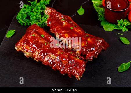 Leckere BBQ-Rippchen mit Petersilie, Spinat und würziger BBQ-Sauce. Stockfoto