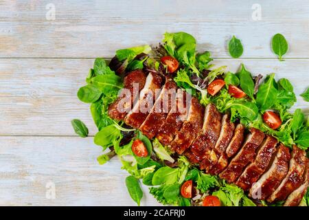 Gegrillte Spare Baby Back Ribs mit grünem Salat und Tomate. Stockfoto