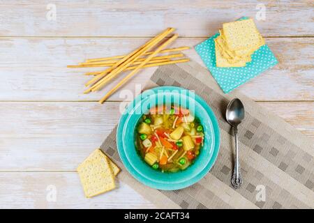 Gesunde Suppe mit Gemüse, Crackern und italienischen Brotstäbchen. Stockfoto