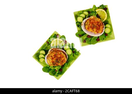 Gefüllte Muscheln mit Krabbenfleisch, gehackten Garnelen und Semmelbröseln mit frischem Salat und Zitrone isoliert auf weißem Hintergrund. Meeresfrüchtekonzept. Stockfoto