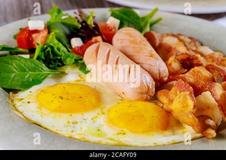 Frühstück mit Ei, Speck, Salat und Wurst. Nahaufnahme. Stockfoto
