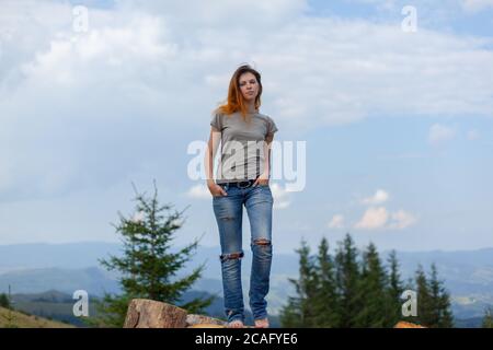 Mädchen in einem T-Shirt und Jeans posiert im Sommer Hoch in den karpaten Stockfoto