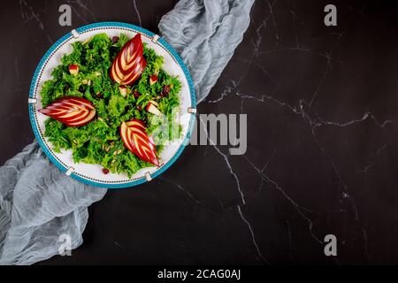 Fitness gesunder Salat mit grünem Grünkohl und Apfel auf schwarzem Hintergrund. Stockfoto