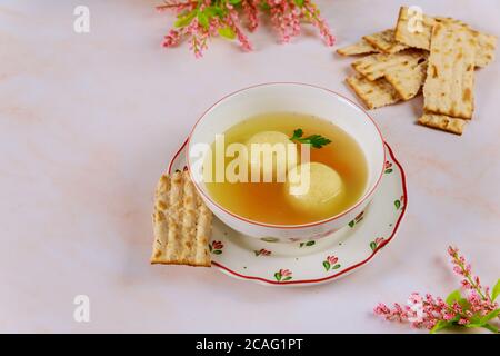 Jüdische Matzoballsuppe auf dem Tisch mit Matzobrot zum Passah. Stockfoto