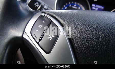 Modernes schwarzes Lenkrad mit Multifunktionstasten für schnelle Steuerung, Nahaufnahme im Auto. Stockfoto