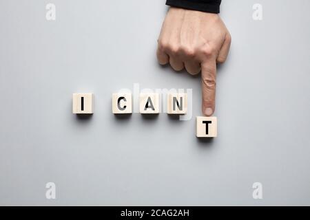 Hand bewegenden Buchstaben und Umwandlung des Wortes, das ich nicht in kann ich auf Holzwürfel. Positives Denken, Motivation, Einstellung und Vertrauenskonzept. Stockfoto