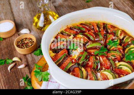 Geschmortes Gemüse Ratatouille mit Mozzarella-Käse in weißer Ofenform. Französisches Gericht. Stockfoto
