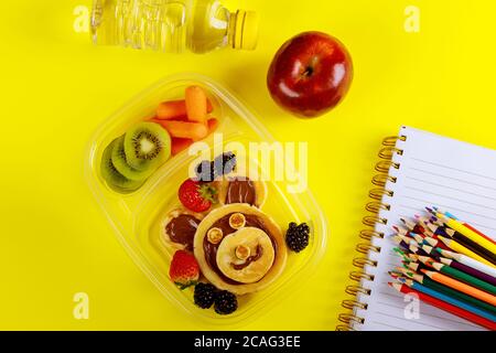 Gesunde Lunchbox mit Pfannkuchen und Haselnussaufstrich, Obst und Gemüse. Zurück zur Schule Konzept. Stockfoto