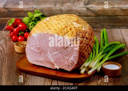 Köstlicher gekochter Schinken auf einem Holzbrett mit grünen Zwiebeln, Salz und Rettich. Stockfoto