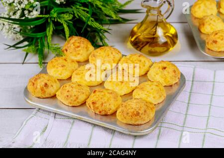 Brasilianische hausgemachte Käsebuns in Backform auf Holztisch. Stockfoto