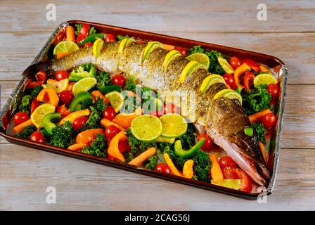 Frischer Hecht mit buntem Gemüse und Gewürzen auf Backblech Stockfoto