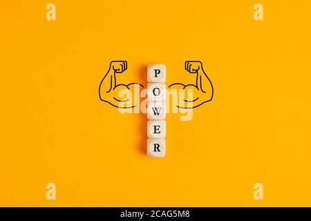 Das Wort Power auf Holzwürfeln mit handgezeichneten Muskelarmen auf gelbem Hintergrund. Konzept der Macht oder mächtig im Geschäft oder Bodybuilding. Stockfoto