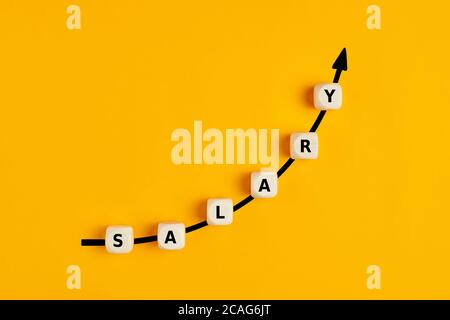 Gehaltserhöhung oder Lohnerhöhung Konzept mit dem Wort Gehalt Geschrieben auf Holzblöcken mit aufsteigender Pfeilgrafik Stockfoto