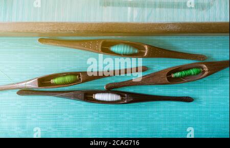 ํTop Ansicht von Garn in Weberei Shuttle-Werkzeug auf Webmaschine. Textilgewebe. Weben mit Webstuhl und Shuttle.Textil oder Tuch. Stockfoto