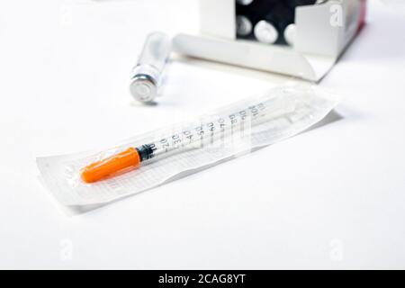 Fläschchen mit Medikamenten und Spritze auf weißem Tisch. Prävention Immunisierung oder medizinisches Konzept. Stockfoto