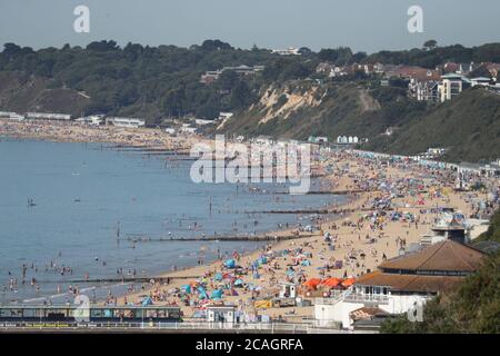 Menschen genießen das heiße Wetter am Bournemouth Strand in Dorset. Stockfoto