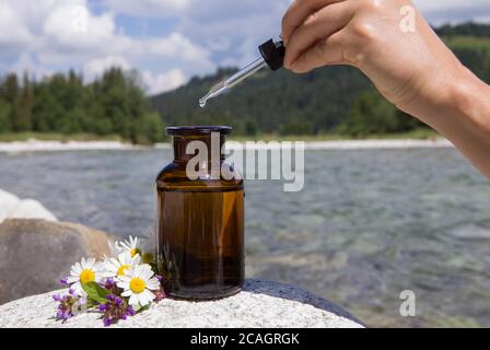 Das ätherische Öl fallen von Glas dropper in organische bio alternative Medizin, braune Flasche. Stockfoto