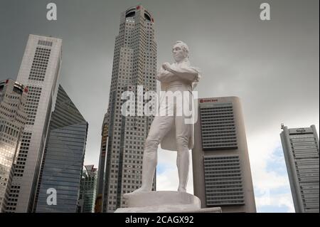 02.07.2020, Singapur, , Singapur - Dunkle Wolken hängen über der Statue von Sir Thomas Stamford Raffles entlang des Singapore River und der Skyline mit sk Stockfoto
