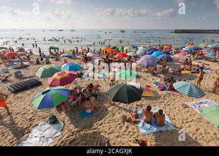 11.08.2018, Cefalu, Sizilien, Italien - Touristen und Einheimische entspannen sich am Stadtstrand unter Sonnenschirmen und schwimmen im Mittelmeer. 00U180811D019CAROEX Stockfoto