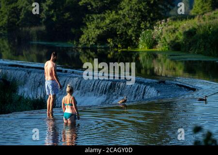 Die Menschen genießen einen frühen Morgenschwimmen in Warleigh Weir auf dem Fluss Avon in der Nähe von Bath in Somerset, wie die Temperaturen sind hoch über dem Vereinigten Königreich eingestellt. Stockfoto