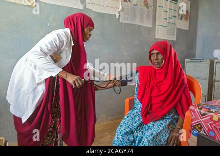 12.11.2019, Denan, Somali Region, Äthiopien - Medizinische Versorgung im Denan Krankenhaus. Ein Arzt überprüft den Blutdruck eines älteren Patienten. Projektdokument Stockfoto