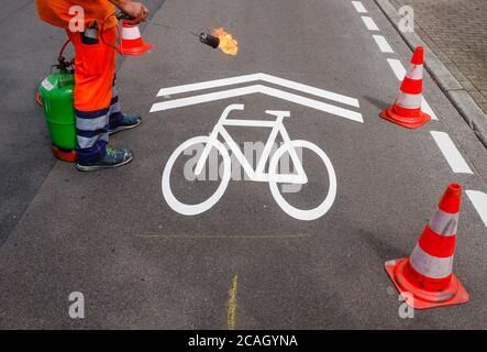 21.07.2020, Essen, Nordrhein-Westfalen, Deutschland - Neue Fahrradstraße, ein Spurmarkierer beim Auftragen der Fahrrad-Piktogramme, hier in der Busehofstraße i Stockfoto