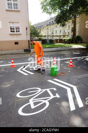 21.07.2020, Essen, Nordrhein-Westfalen, Deutschland - Neue Fahrradstraße, ein Spurmarkierer beim Auftragen der Fahrrad-Piktogramme, hier in der Busehofstraße i Stockfoto