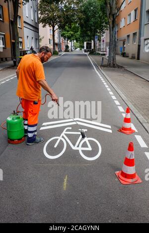 21.07.2020, Essen, Nordrhein-Westfalen, Deutschland - Neue Fahrradstraße, ein Spurmarkierer beim Auftragen der Fahrrad-Piktogramme, hier in der Busehofstraße i Stockfoto