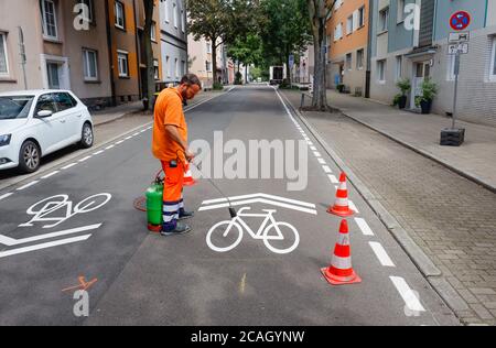 21.07.2020, Essen, Nordrhein-Westfalen, Deutschland - Neue Fahrradstrasse, ein Spurmarkierer beim Auftragen der Fahrrad-Piktogramme, hier die Busehofstrasse Stockfoto