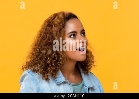 Nahaufnahme Porträt der überraschenden jungen schönen afroamerikanischen Frau Blick in isolierten Studio gelben Hintergrund Stockfoto