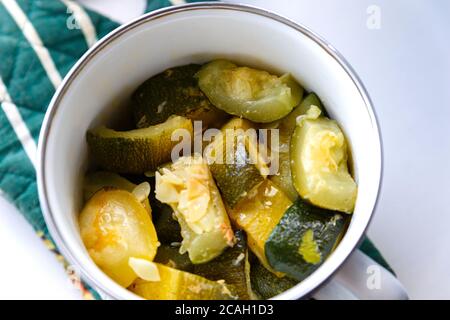 Große Stücke gebratene Zucchini in einem Topf. Große Stücke gebackene Zucchini. Blick von oben. Stockfoto
