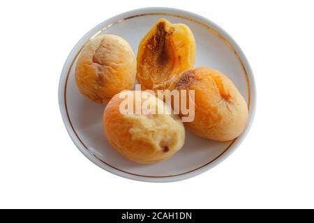 Gruppe von alten Aprikosen in einer Keramikplatte isoliert auf einem weißen Hintergrund. Blick von oben. Stockfoto