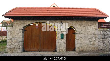 Überdachte Tür und Garageneingang zu einem Haus in Cueto Kantabrien Spanien mit einem roten Ziegeldach und Steinmauer Stockfoto