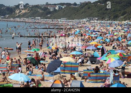 Menschen genießen das heiße Wetter am Bournemouth Strand in Dorset. Stockfoto