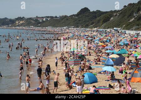 Menschen genießen das heiße Wetter am Bournemouth Strand in Dorset. Stockfoto