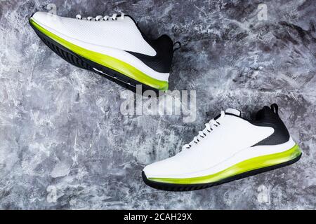 Schwarz-weiße Laufschuhe auf grauem Hintergrund Stockfoto
