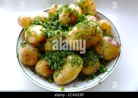 Junge runde Bratkartoffeln in einem Kirami-Teller mit fein gehacktem Dill bestreut. Blick von oben. Stockfoto