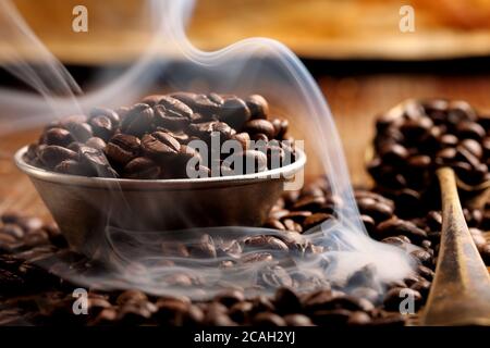 Gerösteter Kaffee und Rauch auf braunem Hintergrund und leer Leerzeichen für Text Stockfoto