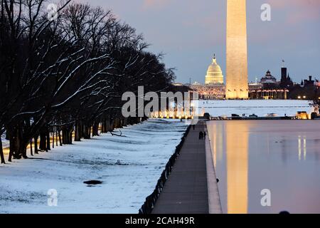 Washington Memorial und Capitol Kuppel spiegelt sich im Pool während Schnee Abend Stockfoto