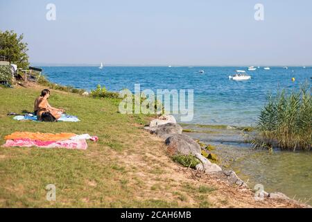 Auf der Insel San Biagio, manerba del Garda, Lombardei, Italien, werden Menschen auf dem Rasen chillen. Stockfoto