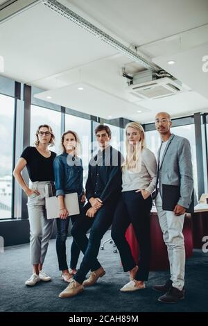Porträt eines Unternehmens Profis stehen zusammen in Büro-Sitzungssaal. Gruppe von Männern und Frauen im Konferenzraum. Stockfoto