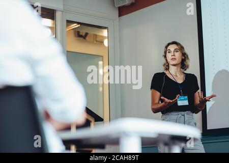 Geschäftsfrau, die Präsentation im Seminar gibt. Weibliche professionelle Austausch ihrer Ideen und Strategien in einer Konferenz. Stockfoto