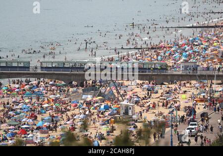 Menschen genießen das heiße Wetter am Bournemouth Strand in Dorset. Stockfoto