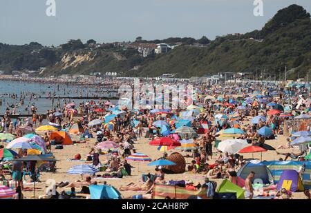 Die Menschen genießen das heiße Wetter am Bournemouth Strand in Dorset. Stockfoto