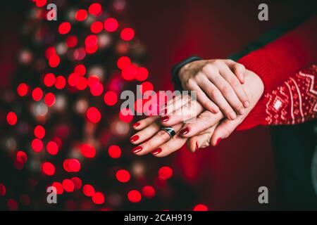 Hände eines frisch vermählten Paares. Auf rotem Hintergrund, Beleuchtung Stockfoto