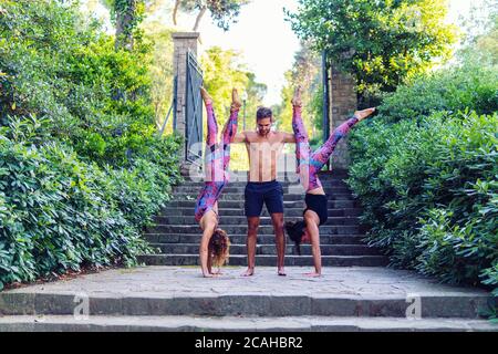 Schöner Mann und zwei Frauen üben acroyoga Stockfoto