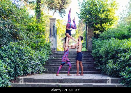 Schöner Mann und zwei Frauen üben acroyoga Stockfoto